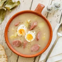 Gęsty żurek z ziemniakami, kiełbasą i jajkiem. Idealny na chłodne dni, a ziemniaki pomagają go zagęścić.