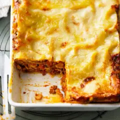 Herzhaftes Lasagne Rezept mit goldbrauner Käsekruste, bereit zum Servieren. Ein Stück wurde bereits entnommen.