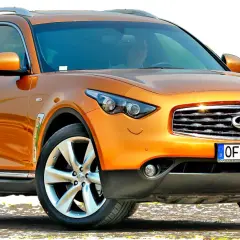 Pomarańczowy infiniti samochód z chromowanymi detalami i felgami.