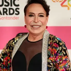 Benita Maestro Joao sonríe en la alfombra roja, luciendo una chaqueta colorida y brillante.
