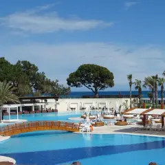 Luksusowy basen z drewnianym mostkiem i palmami, idealne miejsce na relaks w Rixos Turcja.