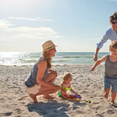 Rodzina na plaży, idealne fajne miejsce na wakacje z dzieckiem w Polsce. Słońce, piasek i radość maluchów.