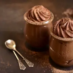 Délicieuse présentation de mousse au chocolat, garnie de cacao, prête à être dégustée avec des cuillères élégantes.