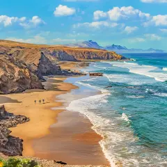 Plaża na Fuerteventurze, gdzie surferzy idą do wody. Tak, Wyspy Kanaryjskie należą do Unii Europejskiej.