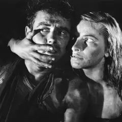Dramatyczna scena z filmu Andrzeja Wajdy. Kobieta zakrywa usta mężczyźnie, ich twarze są spocone i brudne.