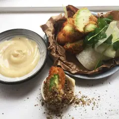Krispigt friterad avokado med en krämig dipp och fräscha grönsaker. En perfekt snack!