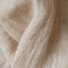 Texture naturelle du lin, évoquant la douceur et la qualité de sa fabrication.