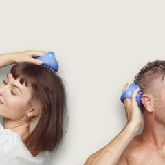 En kvinna och en man njuter av en avslappnande hår massage med blåa borstar.