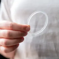 Dłoń trzyma przezroczysty ring dopochwowy.