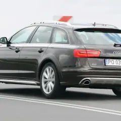 Ciemnobrązowe Audi A6 C6 Avant Allroad jadące po drodze.