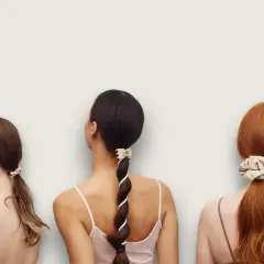 Tre kvinnor med olika frisyrer. En har en tofs i håret, en annan en fläta med band och den tredje en hästsvans med scrunchie.