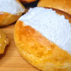 Maritozzi ricetta originale: soffici panini dolci farciti con abbondante panna montata, pronti per essere gustati.