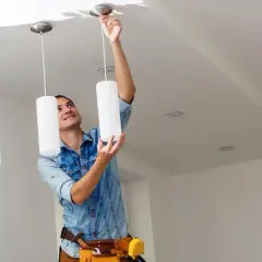 Hombre instalando una lámpara de techo. Aprende como cambiar una lámpara de techo fácilmente.