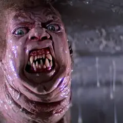 Potwór z klasycznych **filmy sci-fi lata 80.** z przerażającymi zębami i zielonymi oczami, w mokrym, obrzydliwym otoczeniu.