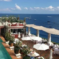Terraza del Hotel Europa con piscina, tumbonas y vistas al mar azul con barcos.