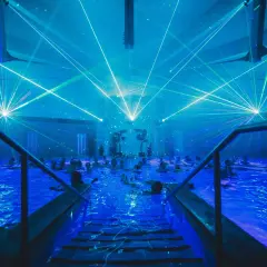 Blaue Laserstrahlen tanzen über einem Pool voller Menschen. Ein unvergessliches Erlebnis bei den Veranstaltungen in Bad Windsheim.