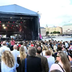 Stor publik njuter av en utomhuskonsert vid vattnet under ett kultur festival.