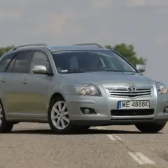 Srebrny kombi Toyota Avensis 1.8 benzyna na drodze.