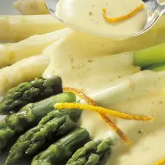 Frischer Spargel, weiß und grün, wird mit einer cremigen Sauce und Orangenzesten serviert. Perfekt zum Spargel kochen.