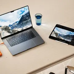 Ein Laptop und ein Tablet mit Berglandschaft, verbunden mit einer externen Festplatte. Ideal für den Datenaustausch zwischen exFAT Windows und Mac.