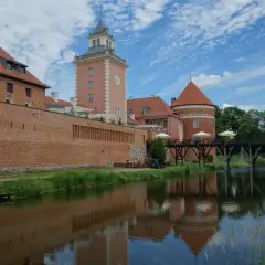 Zamek w Lidzbarku Warmińskim, z wieżą i fosą, to jedna z głównych atrakcji regionu.