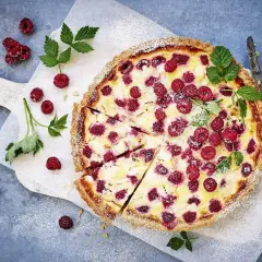 En härlig hallonpaj, perfekt för ett somrigt hallonpaj recept. Garnerad med färska hallon och myntablad.
