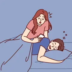 Donna sorpresa guarda il telefono mentre il partner dorme. Come gestire la gelosia in modo sano.