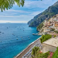 Positano, un luogo perfetto per un weekend con bambini in Campania. Case colorate aggrappate alla scogliera, mare blu e spiaggia animata.