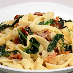 Pyszny makaron z mascarpone, szpinakiem i chrupiącym boczkiem. Kremowy sos otula szerokie wstążki tagliatelle, tworząc idealne danie.
