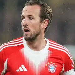 Piłkarz w czerwonej koszulce Bayernu Monachium, Harry Kane, wygląda na zaniepokojonego, być może z powodu kontuzji.