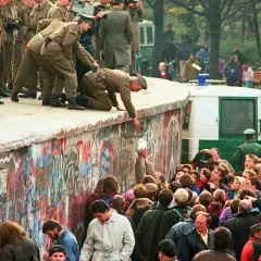 Menschen feiern die Wiedervereinigung Deutschlands am Berliner Mauer. Soldaten helfen Menschen über die Mauer. Eine Zusammenfassung der Freude und des Wandels.