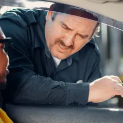 Un policier demande des papiers à un conducteur. Il espère que son nouveau permis de conduire, validité 5 ans, sera en règle.