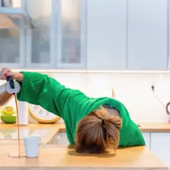 Une personne en peignoir vert, le visage caché, verse du café dans une tasse, symbolisant une perte d'énergie brutale.
