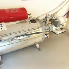 Boiler nautico in acciaio inox e serbatoio rosso. Preparazione per svuotare boiler inverno, con pompe e tubazioni.