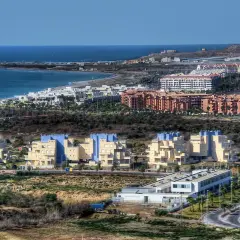 Edificios modernos y el mar azul en Almerimar, Almería. Un paisaje costero con arquitectura contemporánea y la brisa marina.