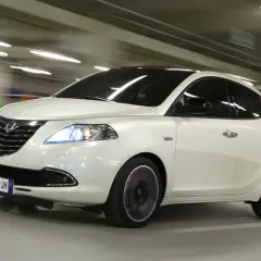 Lancia Ypsilon a metano in movimento in un parcheggio.