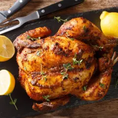 Pollo asado al horno, dorado y jugoso, con limones y hierbas frescas. ¡Listo para servir!