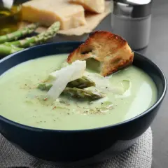 Aksamitny zupa krem ze szparagów zielonych, udekorowana świeżymi szparagami, parmezanem i grzanką. Idealna na wiosenny obiad.