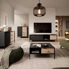 Nowoczesny salon z meblami w kolorze dąb Wotan, czerni i zieleni. Wygodna sofa, stolik kawowy i komoda tworzą przytulną przestrzeń.