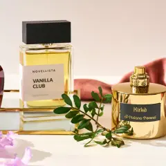 Eleganckie flakony edp perfumy: czerwony Xerjoff, Vanilla Club Novellista i złoty Kirke Tiziana Terenzi, otoczone kwiatami i gałązką.
