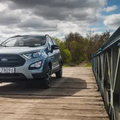 Srebrny Ford Ecosport na drewnianym moście, gotowy na przygodę.
