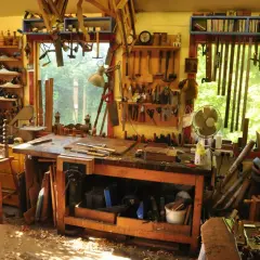 Un laboratorio pieno di attrezzi mostra come si lavora il legno: pialle, seghe, scalpelli e un banco da lavoro pronto per creare.