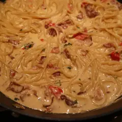 En krämig pasta med knaprigt bacon och tomater i en panna. Enkel och god vardagsmat.