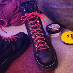 Black hiking boots with bright red laces, ready for adventure. Why do hiking boots have red laces? For a pop of color and to stand out on the trail!