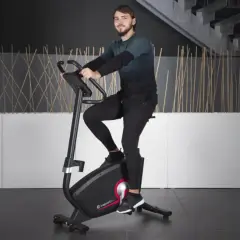 Mężczyzna ćwiczy na rowerze stacjonarnym, jednym z wielu rodzajów rowerów stacjonarnych dostępnych na rynku.
