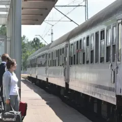 Ludzie z bagażami czekają na pociąg PKP. Zastanawiasz się, kto ma zniżki na PKP? Sprawdź ofertę przewoźnika!