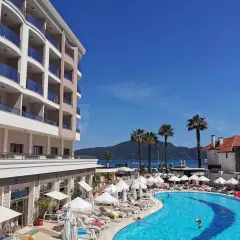 Fajny hotel nad morzem z basenem i palmami. Słoneczny dzień, idealny na wakacje.