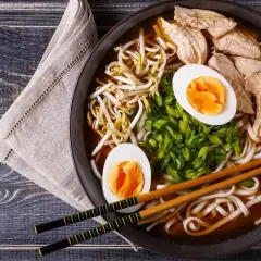 A miseczce shoyu ramen z kurczakiem, jajkiem na twardo, kiełkami fasoli mung i szczypiorkiem.