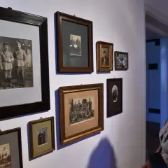 Kobieta ogląda galerię starych fotografii. Czy robienie komuś zdjęć jest karalne? W tym przypadku to historia uwieczniona na papierze.