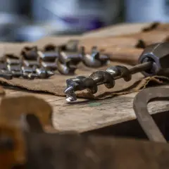 Utensili da falegnameria, tra cui punte elicoidali, per imparare come bucare il legno senza trapano.